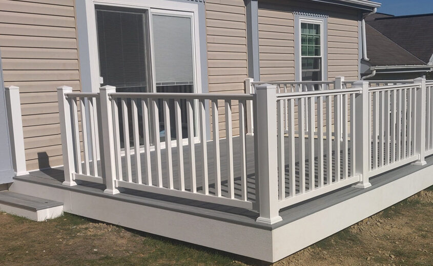 Elevated wood deck featuring custom white railings, designed by JL Home Builders, showcasing modern outdoor living space.