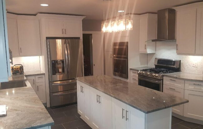 White kitchen with island, pendant lights, and stainless appliances, JL Home Builders, Pittsburgh