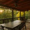 Covered patio with dining set overlooking the woods