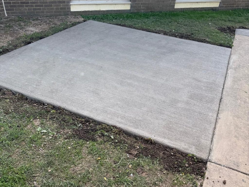 Cured concrete pad poured beside a brick building with forms removed, JL Home Builders, Pittsburgh