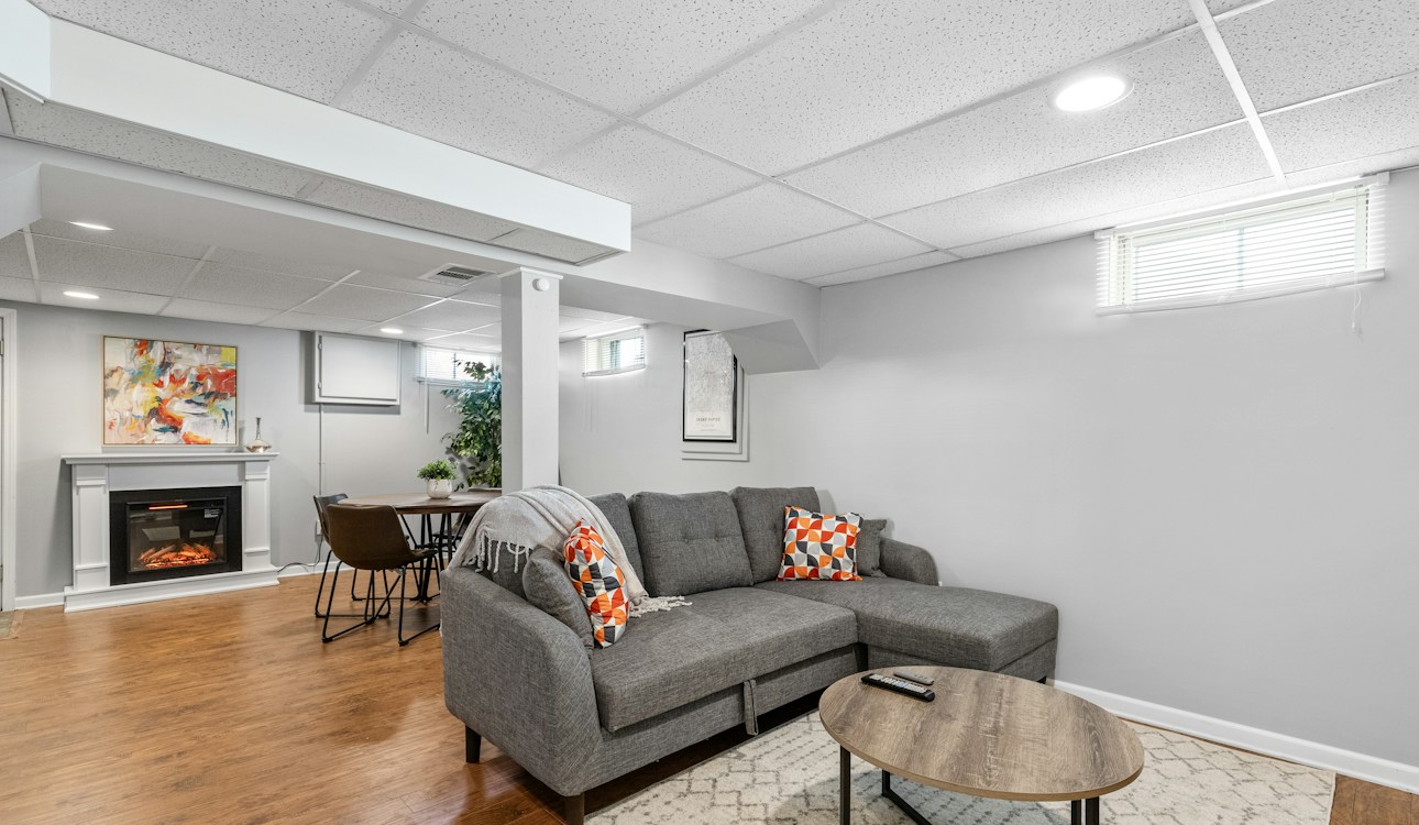 Finished basement living room with fireplace and sofa