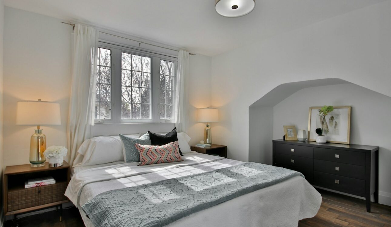 Finished bedroom with fresh paint and a made bed in an older home