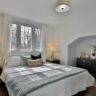 Finished bedroom with fresh paint and a made bed in an older home