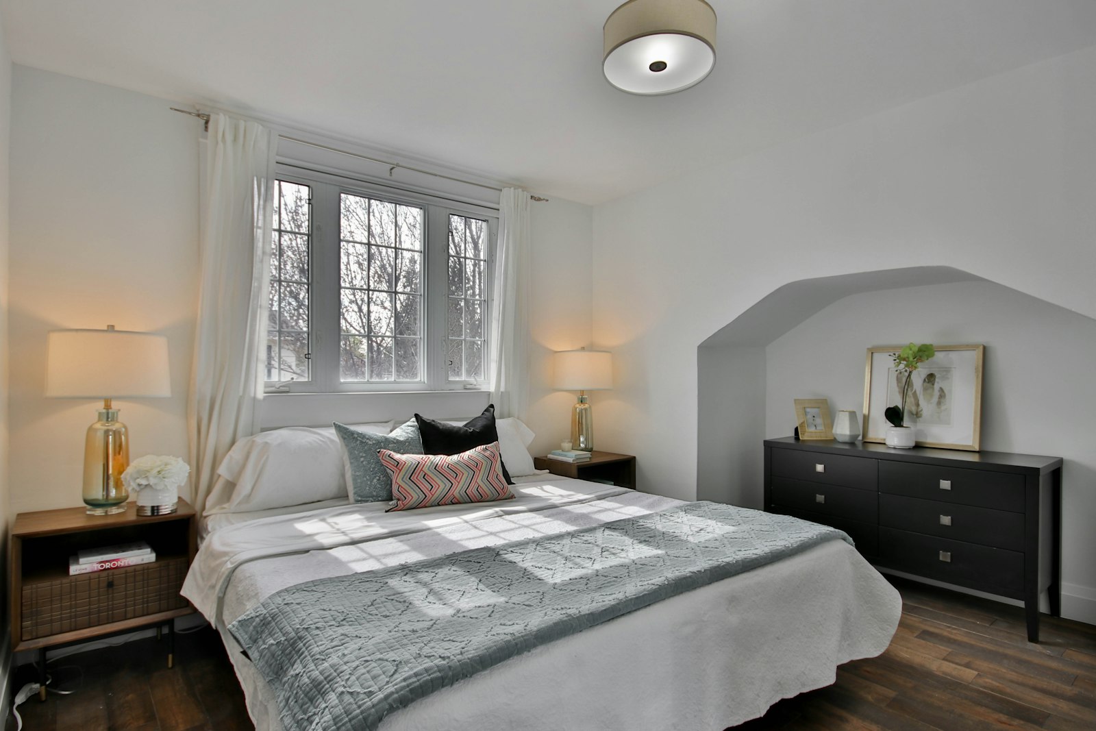 Finished bedroom with fresh paint and a made bed in an older home