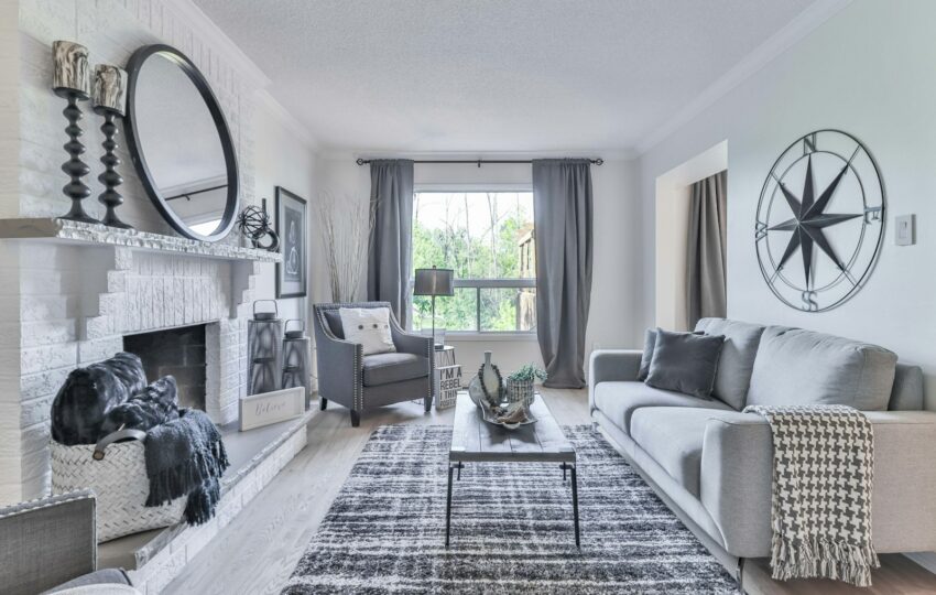 Finished living room with gray sofas, a fireplace, and new flooring