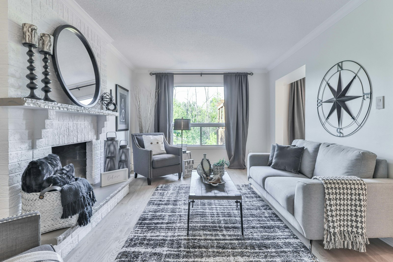 Finished living room with gray sofas, a fireplace, and new flooring