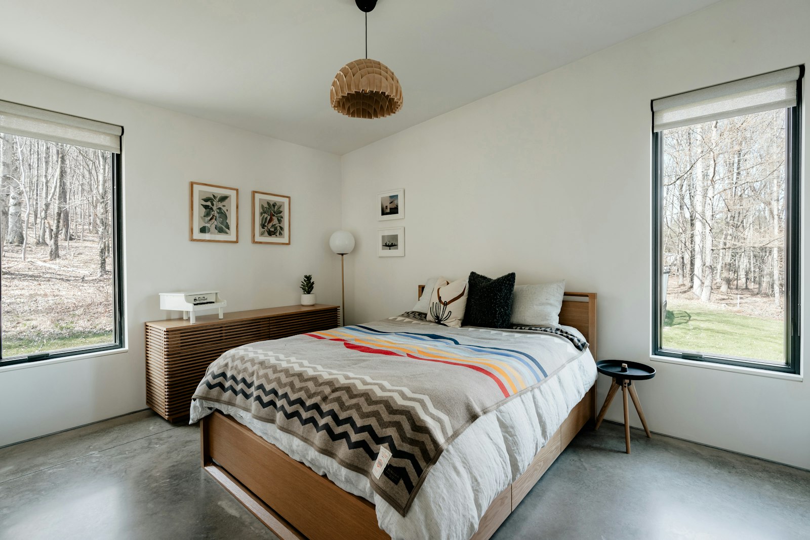 First-floor bedroom with large windows and a made bed