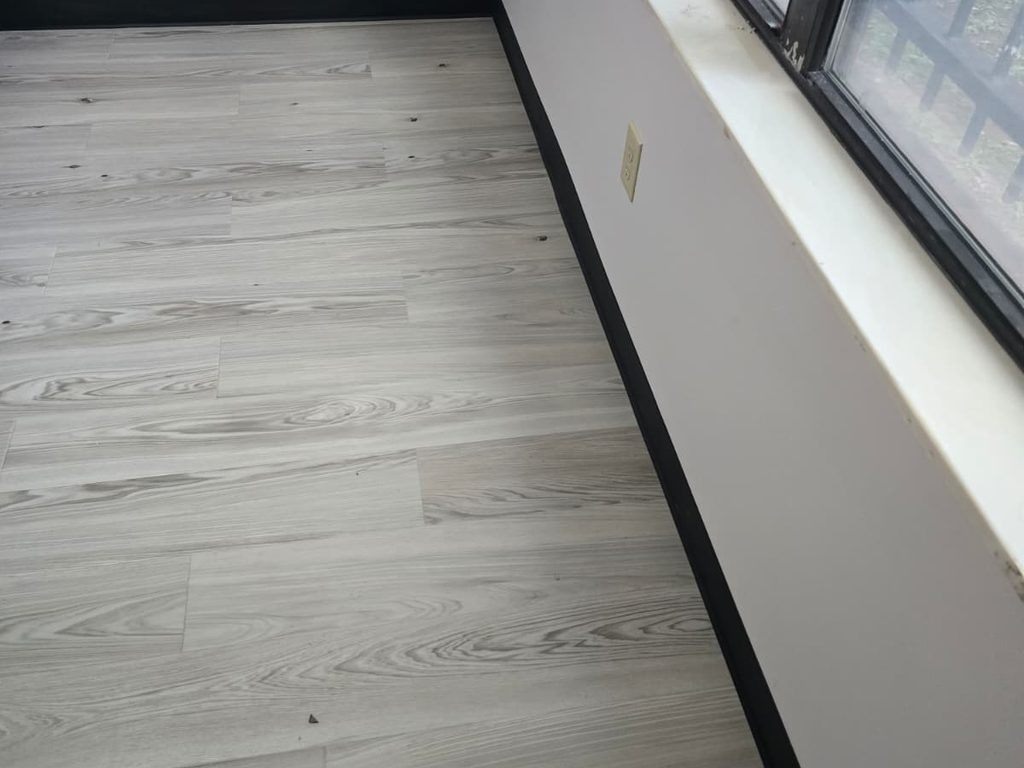 Gray luxury vinyl plank flooring with black cove base, JL Home Builders, Pittsburgh
