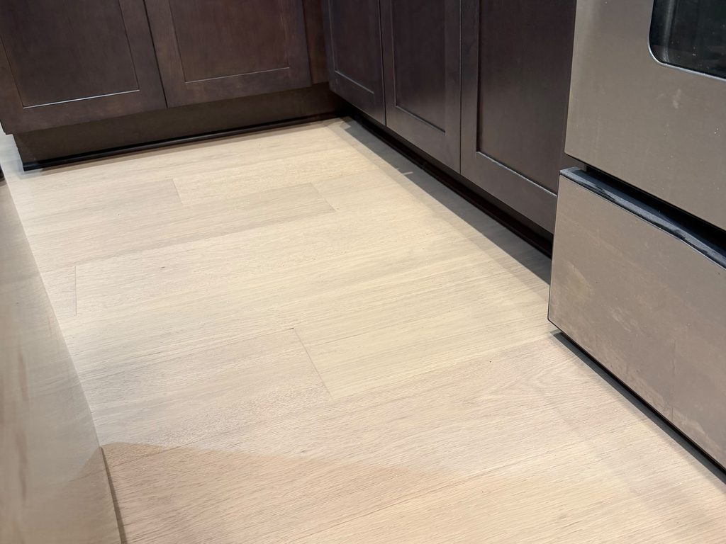 Light oak flooring meeting dark shaker cabinets, JL Home Builders, Pittsburgh