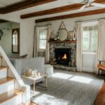 Living room with a fireplace, hardwood floors, and a staircase in an older home