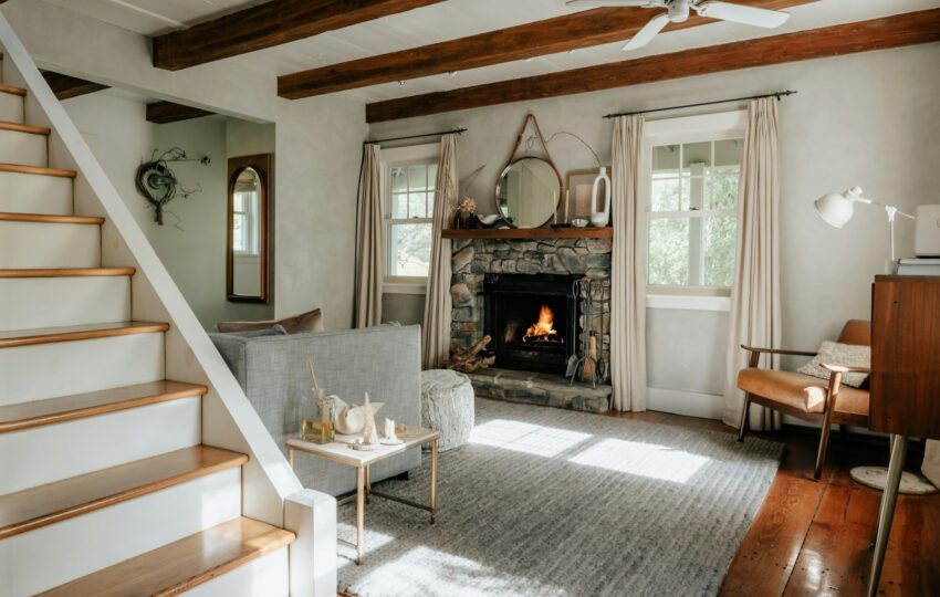 Living room with a fireplace, hardwood floors, and a staircase in an older home