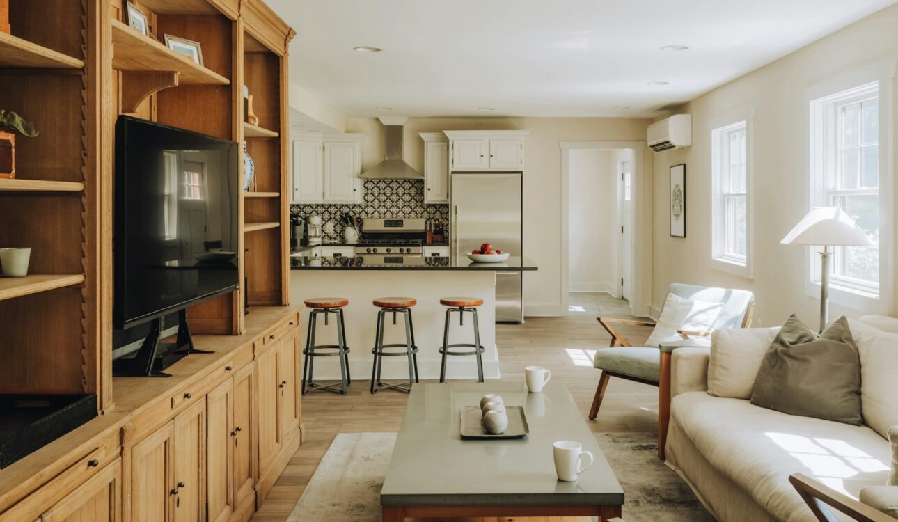 Open concept living room flowing into a kitchen with built-in shelving