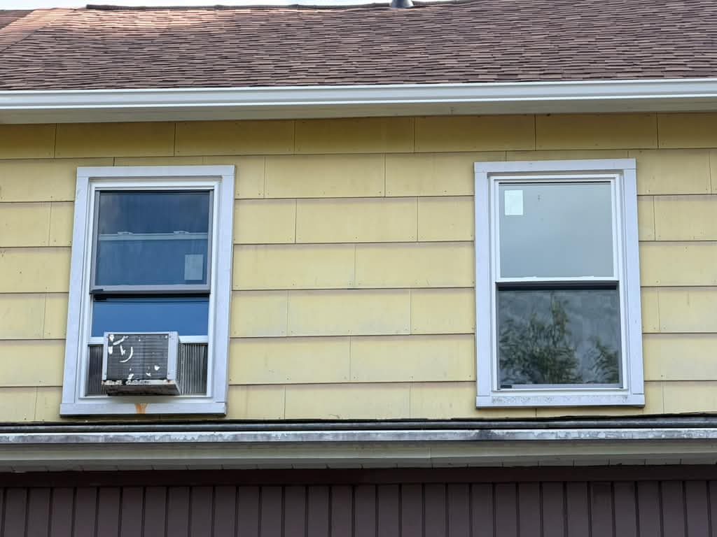 Two new replacement windows on the upper floor of a yellow-sided Pittsburgh home, JL Home Builders