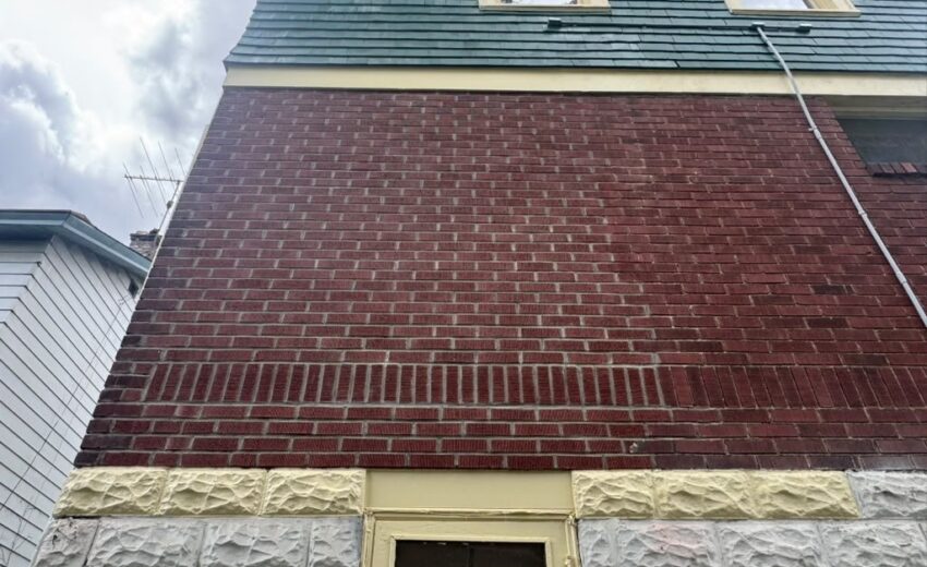 Finished brick wall with stone trim along the bottom after the bump out was removed