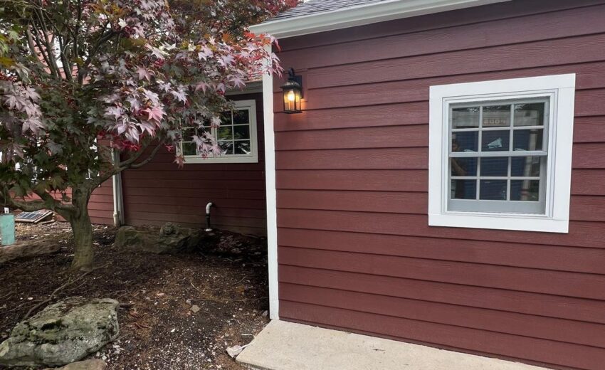 Rear addition with red siding, white trim and a new window