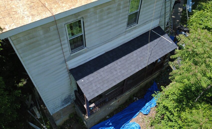 New dark shingle roof on a two story house with a chimney