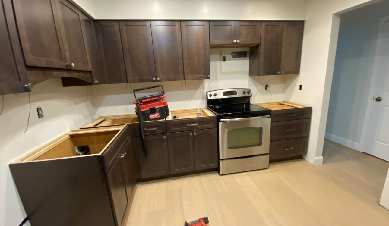 Dark shaker kitchen cabinets installed with the range in place before the countertops go on