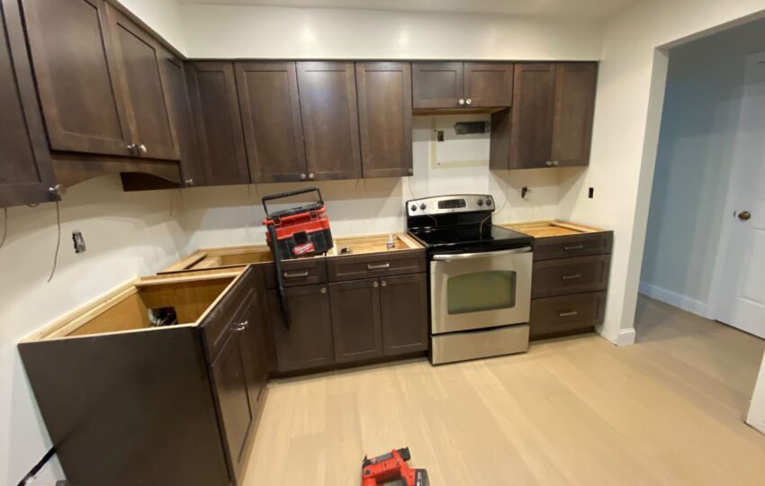 Dark shaker kitchen cabinets installed with the range in place before the countertops go on