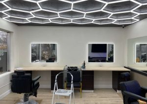 Custom barbershop interior featuring hexagonal LED ceiling design, illuminated mirrors, and modern workstations at Shop 724 Barbershop in Irwin, PA.