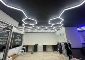 Custom hexagonal LED ceiling design in Shop 724 Barbershop, showcasing modern lighting installation and workspace ambiance.