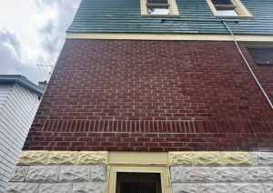 Finished brick wall with stone trim along the bottom after the bump out was removed