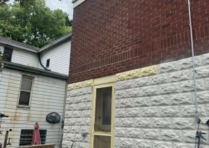 Brick wall finished down to the stone trim next to a screen door