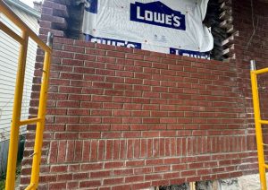 Pallets of brick staged beside scaffolding while the wall was rebuilt
