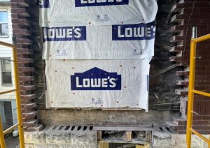Wall wrapped in house wrap with the first rows of brick laid below