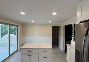 White cabinets and a center island on a gray tile floor
