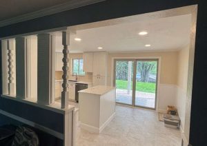 Open kitchen with white cabinets and a center island seen from the doorway