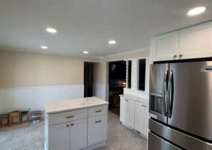 Kitchen with white cabinets, a center island and a stainless steel refrigerator