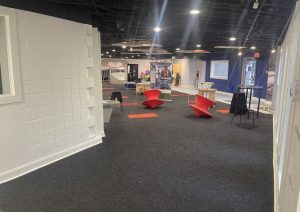 Children aviation museum exhibit floor with charcoal carpet and orange accents