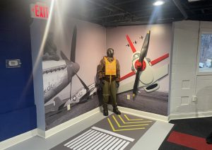 Pilot display beside an aircraft mural with runway markings on the floor