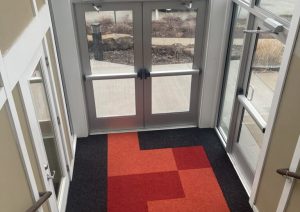 Museum entrance with glass doors and matching carpet tile