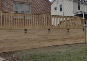 Elevated pressure-treated wood deck with custom railings and built-in lighting, enhancing outdoor space for a Pittsburgh home.