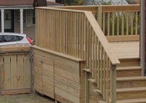 Elevated pressure-treated wood deck with custom railings and built-in storage, showcasing quality craftsmanship in a residential setting.