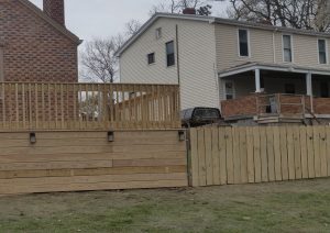 Elevated pressure-treated wood deck with custom railings and built-in lighting, showcasing craftsmanship in a Pittsburgh neighborhood home.