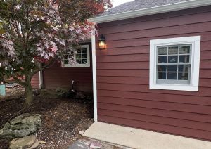 Rear addition with red siding, white trim and a new window
