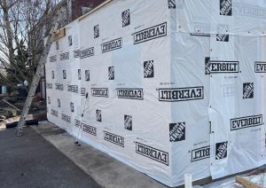 Addition wall wrapped in house wrap during construction