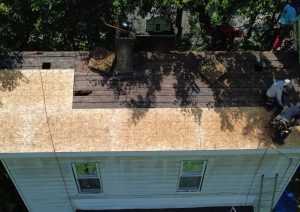 New dark shingles on the roof of a white house seen from the front