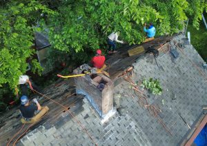 Roof with half of the old shingles removed and new plywood decking started