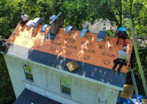Underlayment and starter row installed on the roof with crew at work