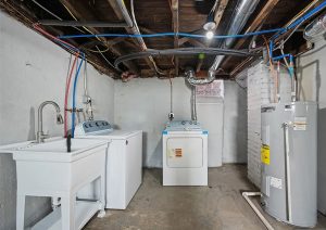Laundry room renovation featuring new washer and dryer, utility sink, and updated plumbing in a modern home in Etna.