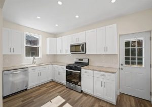 Modern kitchen renovation with white cabinetry, stainless steel appliances, and natural light, showcasing the complete home renovation by JL Home Builders in Etna.
