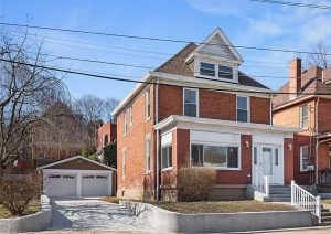 Complete home renovation exterior view of a brick house in Etna, showcasing modern updates and a well-maintained garage, reflecting JL Home Builders' commitment to transforming outdated properties into inviting living spaces.