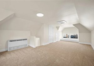 Spacious, renovated attic space with neutral tones, new carpet, modern lighting, and improved electrical features, showcasing a complete home renovation by JL Home Builders in Etna.