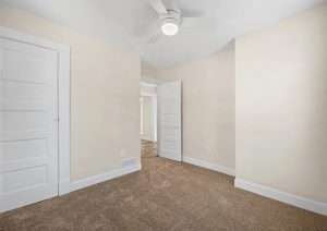 Bright, renovated interior space featuring neutral walls, new carpet, modern ceiling fan, and updated doors in a complete home renovation by JL Home Builders in Etna.