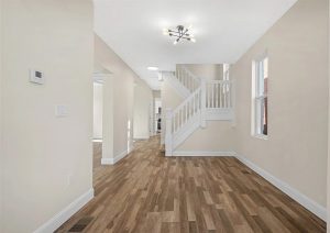 Modern interior of a renovated home in Etna featuring new wood flooring, neutral wall colors, and contemporary lighting, showcasing an open layout and updated staircase.